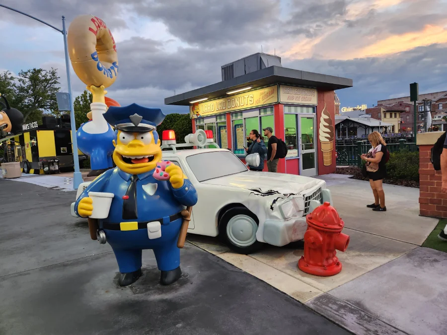 El jefe Gorgory de los Simpsons al lado de un auto chocado en Universal Orlando