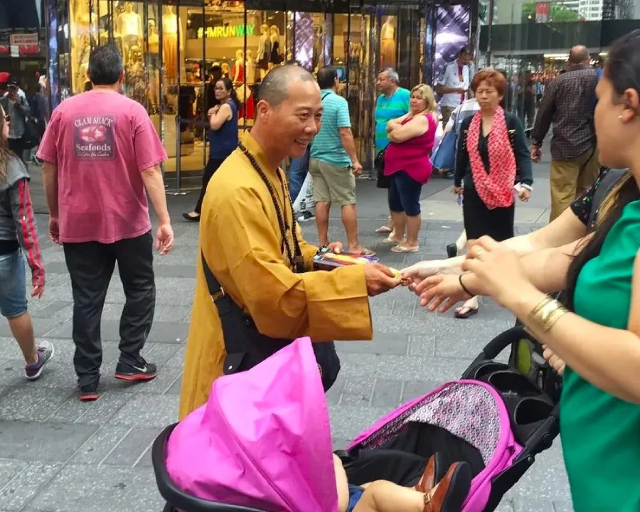 Falso monje budista haciendo una de las trampas más típicas de Times Square