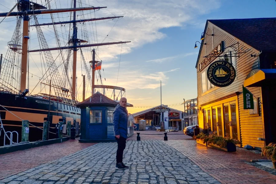 Oli parado en Bowen´s Wharf, Newport al atardecer con el sol dorado iluminando los edificios