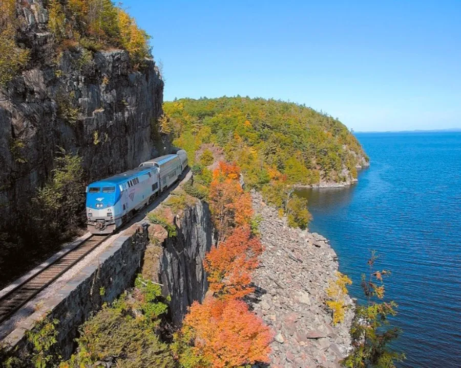 1_trennewyork El Adirondack de Amtrak pasando por unas vias al borde de un risco sobre el río Hudson con el foliage de otoño. Uno de los mejores viajes en tren desde Nueva York