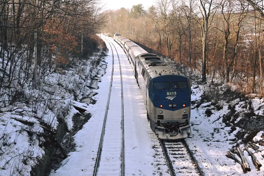 EL Downeastern de Amtrak viajando por un paisaje boscoso y nevado de Nueva Inglaterra
