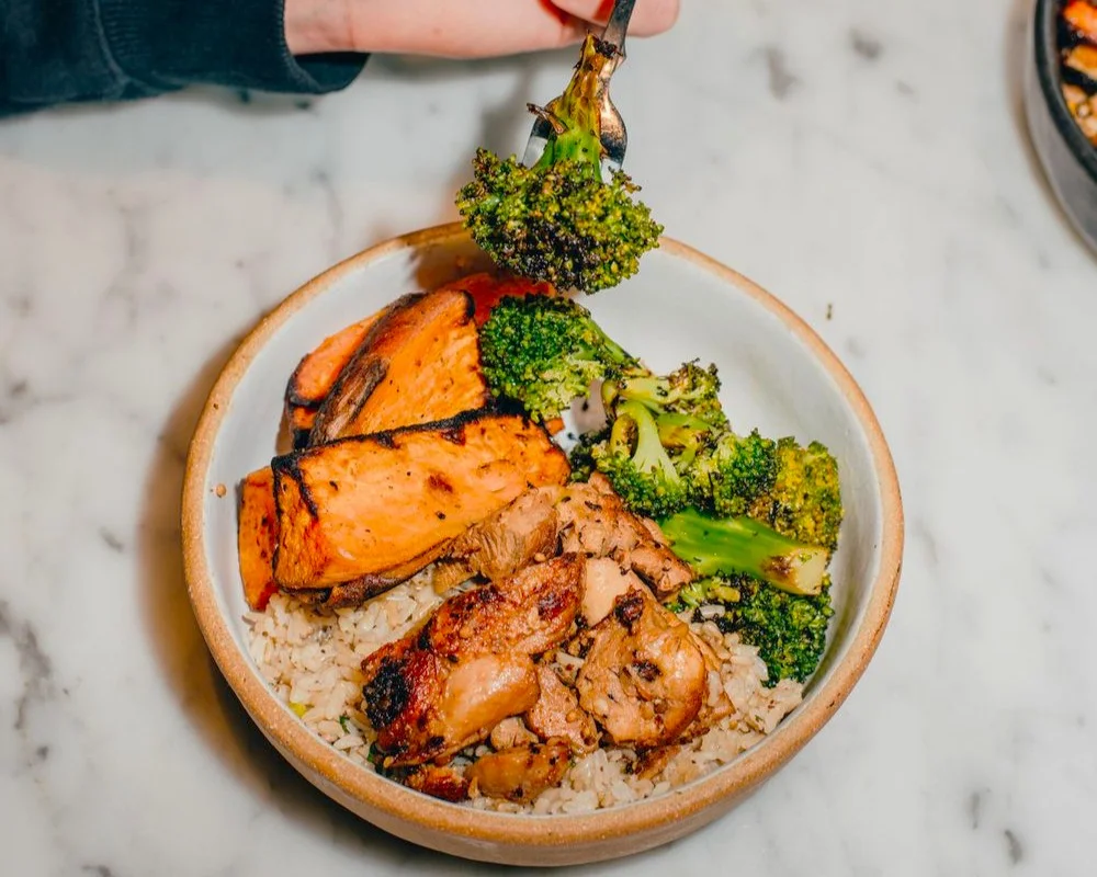 4_comidasaludable_nueva_york Plato de salmón a la plancha con arroz integral y verduras en un bowl blanco.