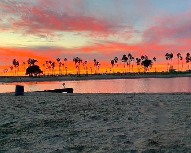 4_parques_sandiego Atardecer en Mission Park de San Diego con el cielo naranja reflejándose en el agua y las palmeras en silueta negra