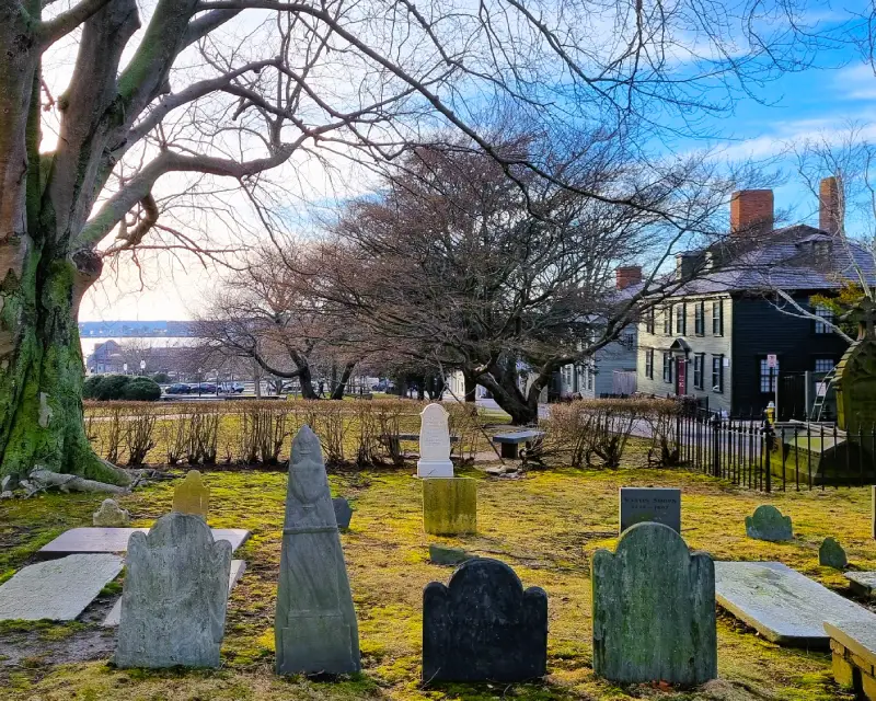 7_newport Cementerio antiguo con el mar y casas de madera al fondo en el distrito histórico de Newport, Rhode Island