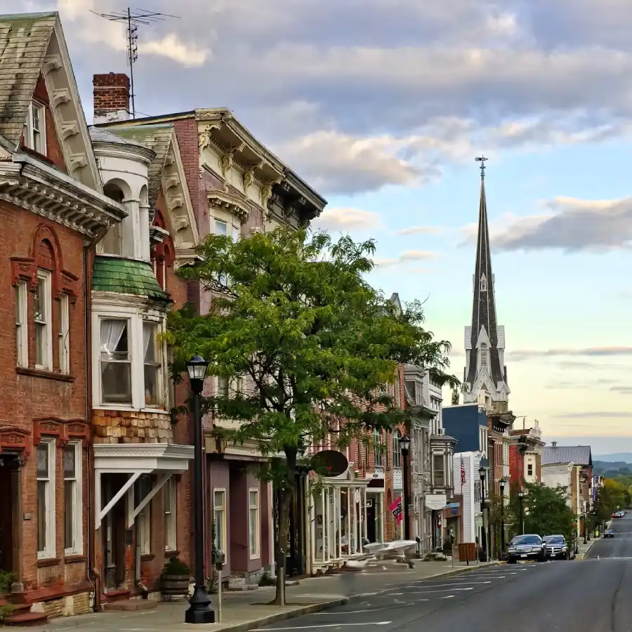 _pueblo_ny_hudson.. Calle del pueblo de Hudson New York con casas de ladrillos rojos y la torre de la iglesia al fondo