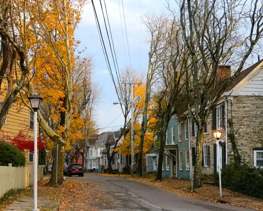 pueblos_ny_kingston Calle de Kingston New York un día de otoño con casas residenciales y árboles con hojas amarillas