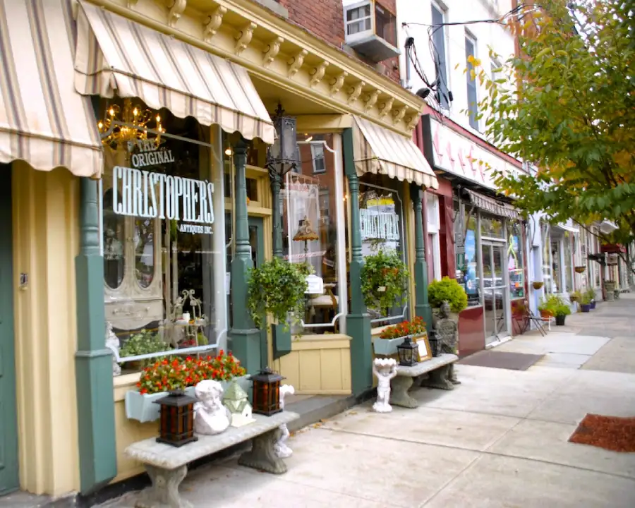 pueblos_ny_nyack Tienda acogedora con clumnas verdes y toldos amarillos y marrones a rayas estilo siglo XIX en la calle principal del pueblo de Nyack, New York